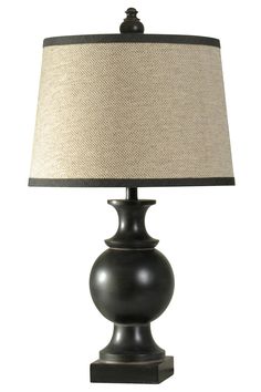 a black lamp with a beige shade on the base and a white linen lampshade