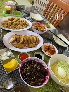 a table topped with plates filled with different types of food next to bowls and utensils