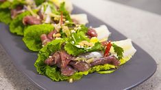 some lettuce and meat are on a blue plate with chopsticks next to it