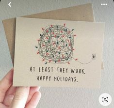 someone holding up a card that says at least they work, happy holidays