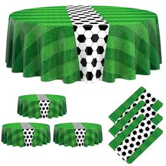 a green table cloth with black and white soccer balls on it, along with matching napkins