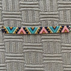 a knitted bracelet with multicolored triangles on it