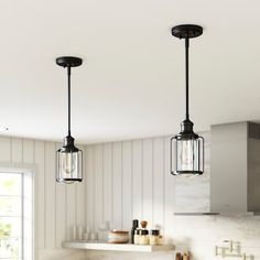 three lights hanging from the ceiling in a kitchen