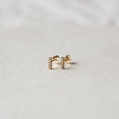 Pretty & simple stud earrings adorned with little cubic zirconia stones — perfect for your everyday.•  14k gold plating over sterling silver (hypoallergenic & nickel-free)•  Matching post backing•  Measures about 7mm long•  Ships as a pair (2 earrings total)Every order comes nicely packaged, ready for gift-giving! Please note that multiple items in the same order will be combined into one gift box. If the items are meant for separate individuals, please let me know.Shorter version availa Jewelry Necklace Simple, Simple Stud Earrings, 2 Earrings, Geometric Studs, Minimalist Studs, Tiny Studs, Tiny Stud Earrings, Small Earrings Studs, Minimal Jewelry