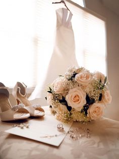 a bridal bouquet and wedding shoes on a table