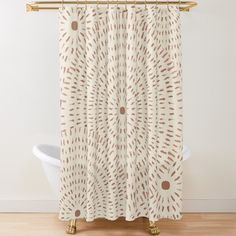 a white shower curtain with brown circles and dots on the bottom, in front of a bathtub