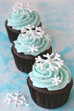 three cupcakes decorated with frosting and snowflakes