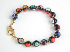 Vintage, Millefiori, 8mm Round Venetian Beads, Black Background, Multicolored Mosaic Canes, Murano Glass, Italian Bracelet. Length is approximately 7 1/4 inches. Bracelet is hand knotted, and each bead is accented with gold, decorative, Italian, filigree, bead caps. Traditional Black Bracelets With Large Beads, Vintage Black Round Bead Bracelets, Italian Bracelet, Bead Caps, Murano Glass, Black Background, Black Backgrounds, Mosaic, Jewelry Bracelets