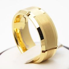 a gold wedding ring on top of a white surface