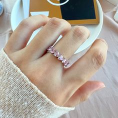 a woman's hand with a pink diamond ring on top of her left hand