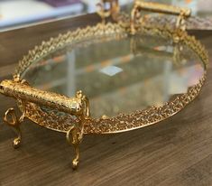 an ornately decorated gold tray on top of a wooden table