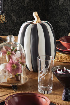 Style your home for Halloween with classic pumpkin decor and festive accents your guests will love. Start with a black-and-white striped pumpkin with gold details for a sophisticated centerpiece. Pair it with a cloche filled with a skull and flowers for an artful display, then add enameled skeleton drinking glasses and timeless red dishware to set a mood that's both playful and polished.

Shop for your home at Birch Lane. Skeleton Drinking, Skull And Flowers, Strawberry Blonde Hair Color, Strawberry Blonde Hair, Pumpkin Decor, A Skull, Strawberry Blonde