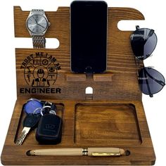 an iphone, sunglasses, cell phone and other items in a wooden holder with the words engineer on it