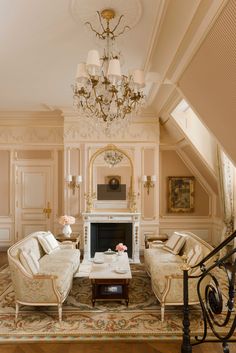 an elegant living room with chandelier and couches