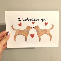 a person holding up a card with two dogs on it that says i love labrador you