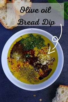 a white bowl filled with soup next to slices of bread on top of a blue surface