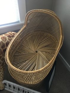 a giraffe standing next to a wicker basket on top of a floor