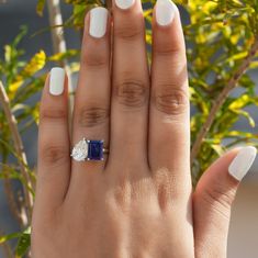 a woman's hand with a ring on it and a blue stone in the middle