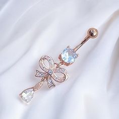 Super cute y2k 2000s rose gold diamond rhinestone ribbon bow heart dangling belly piercing ring bar.  Surgical steel  FREE STANDARD UK SHIPPING Trendy Bling Jewelry As A Gift, Elegant Body Jewelry With Bling For Gifts, Elegant Cubic Zirconia Belly Rings As Gift, Dangle Belly Rings For Wedding, Elegant Metal Belly Rings As Gift, Elegant Metal Belly Rings For Gift, Dainty Metal Body Jewelry As Gift, Elegant Gold Belly Rings Gift, Elegant Dangle Belly Rings For Wedding