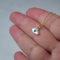 Εxtra tiny 14k solid gold evil eye pendant.  The pendant measures 11mm / 0.4 inches The evil eye pendant is available in 14k yellow gold with a white evil eye.  The  eye is made of mother of pearl (mop). The backside is closed, smooth 14k solid gold. Available with a solid 14k gold chain or as pendant only. Chains are available in 3 lengths, 16inches/40cm, 18inches/45cm and 20 inches/50cm Perfect gift for Valentine or any other special occasion. Comes in a gift box. Everyday Yellow Gold Evil Eye Charm Necklaces, White 14k Gold Round Charm Necklaces, White 14k Gold Round Charm Necklace, Dainty Yellow Gold Evil Eye Charm Necklace, Fine Jewelry Featuring Evil Eye, 14k Gold Evil Eye Charm Necklace, 14k Yellow Gold Evil Eye Charm Necklace, 14k Yellow Gold Evil Eye Jewelry, 14k Yellow Gold Jewelry With Evil Eye