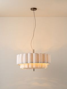 a chandelier hanging from the ceiling in a room with white walls and flooring