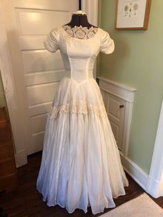 a white dress on display in front of a door