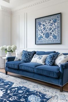 a living room with blue couches and rugs in front of a painting on the wall