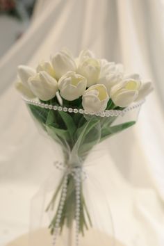 a bouquet of white tulips in a clear vase