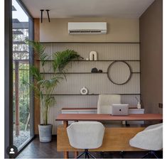 a room with a desk, chair, and air conditioner on the wall above it