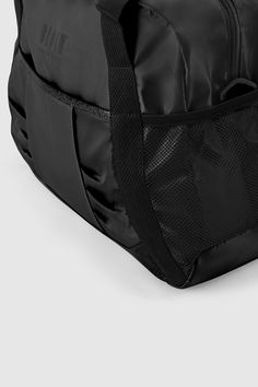 a black duffel bag sitting on top of a white floor