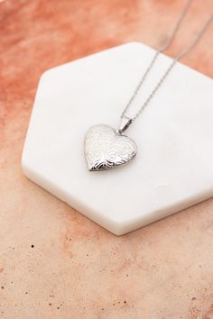 The Love Me Heart Heart Locket Necklace is the perfect way to show someone you care. Available in gold and silver, this cute necklace is a perfect gift for any occasion. Spread love and happiness with this adorable accessory. #lovemyleto #completeyourlook 100% Stainless Steel Imported Heart-shaped Stainless Steel Jewelry, Stainless Steel Heart Charm Pendant Necklace, Heart Cut Locket Necklace For Valentine's Day, Silver Heart Necklace With Heart Detail, Stainless Steel Heart Pendant Necklace With Charm, Valentine's Day Heart Cut Locket Necklace, Engraved Heart Stainless Steel Charm Necklace, Stainless Steel Heart Charm Jewelry, Silver Stainless Steel Heart Necklace