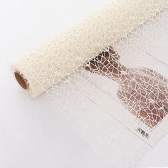 a roll of white mesh sitting on top of a table next to a piece of paper