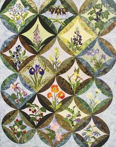 a quilted wall hanging with flowers and leaves on it's sides, all in different shapes and sizes