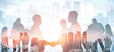 silhouettes of business people standing in front of a cityscape with skyscrapers