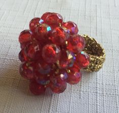 "Red 60s or 70s Big Ring with a band made of gold Stretchy fabric, so it's one size fits all. The ring is basically a 1\" mound of Ruby Red Faceted plastic stones, woven into a shiny red mound. Also, please take a look at my storefront at: https://www.etsy.com/shop/FabFinds42?ref=seller-platform-mcnav I have a wide selection of one-of-a-kind items, from clothing and toys to home decor and gift items, and I add new things almost every day." Round Red Ruby Party Ring, Party Ruby Ring With Round Shape, Vintage Adjustable Red Ruby Ring, Adjustable Vintage Ruby Ring, Party Ruby Ring, Handmade Adjustable Red Ruby Ring, Hippie Ring, Stretchy Rings, Shiny Rings