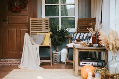 two wooden chairs sitting next to each other on a porch