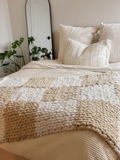 a bedroom with a bed, mirror and plants