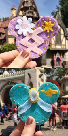 someone holding up a mickey mouse cookie in front of a castle