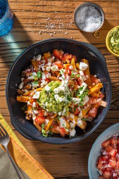 a bowl filled with lots of food on top of a wooden table