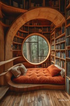 a room with bookshelves and a window that looks like a tree house in the woods