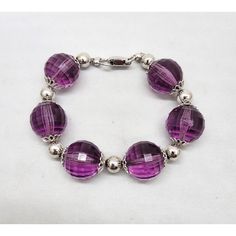 Early 1960s rhodium plated faceted purple resin beads with filigree detail terminals and round rhodium plated bead spacers and fold over clasp. Marked "NAPIER." Measures: 8 1/2 inches long by 3/4 inches wide. Interior circumference due to the thickness of the beads is about 7 1/4 inches. Excellent condition. Round Faceted Amethyst Beads Jewelry, Purple Round Beads Costume Jewelry, Amethyst Faceted Beads Jewelry, Purple Round Bead Costume Jewelry, Purple Round Beaded Costume Jewelry, Round Amethyst Jewelry With Faceted Beads, Elegant Purple Jewelry With Round Beads, Purple Round Beads Jewelry For Party, Purple Faceted Beads Jewelry For Party