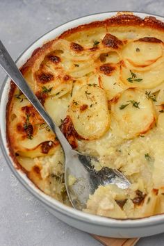 the best scalloped potatoes in a bowl with a spoon