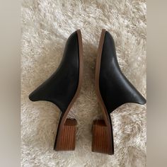 New Never Worn Black Slip-on Heels For Spring, Trendy Black Mules With Round Toe, Trendy Black Flat Heel Mules, Trendy Black Closed Toe Mules, Trendy Black Mules For Spring, Casual Black Mules For Spring, Black Flat Heel Mules For Spring, Black Slip-on Mules For Spring, Black Mules With Wooden Low Heel