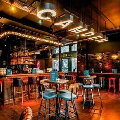 the inside of a restaurant with stools and tables