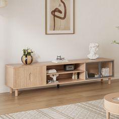 a living room with a wooden entertainment center and vases on the side table in front of it