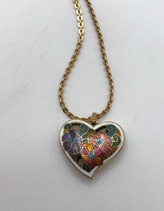 Vintage Cloisonné enamel pendant Circa 1970s this cute heart pendant has metallic cloisonné enamel. Puffy design cut outs and reversible with design and enameling on both sides Unsigned In very good condition.Any wear such as an occasional small scratch is minor.  Includes a Monet chain from the same era with hang tag and sister clasp  Heart is about 1 inch X 1 inch Chain is about 18 inches in length Retro Enamel Necklaces For Gift, Vintage Enamel Heart Necklaces, Vintage Heart Enamel Necklaces, Vintage Enamel Heart Necklace, Vintage Heart Enamel Necklace, Puffy Design, Cloisonne Enamel, Cute Heart, Open Heart