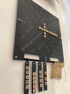 a wall mounted scrabble board with wooden letters and numbers attached to the back of it