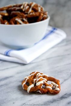 a bowl of pretzels sitting on top of a table next to a napkin