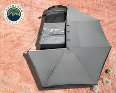 an open umbrella sitting on top of a dirt ground