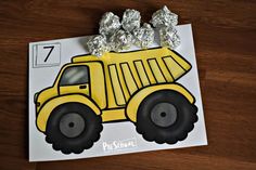 a piece of foiled paper with a construction truck on it and some silver foil